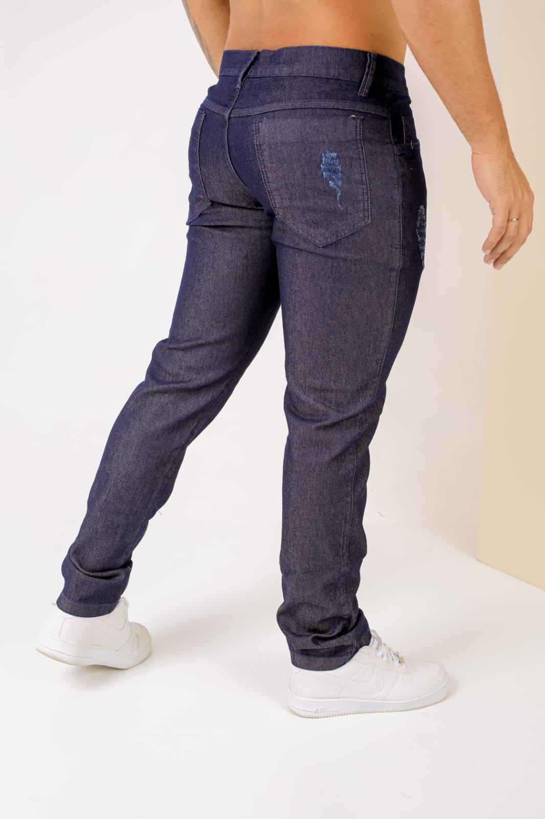 Calça de sarja slim masculina escura com detalhe no bolso traseiro em relevo
